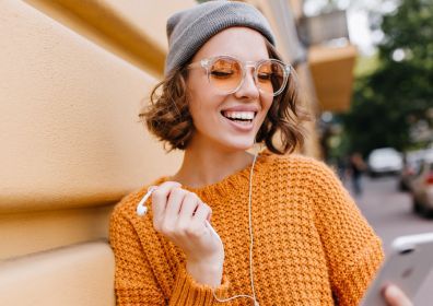 Smiling girl with headphones and mobile phone